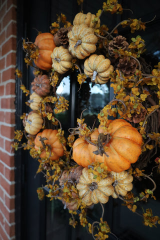 Decorative wreath with pumpkins and gourds on a door